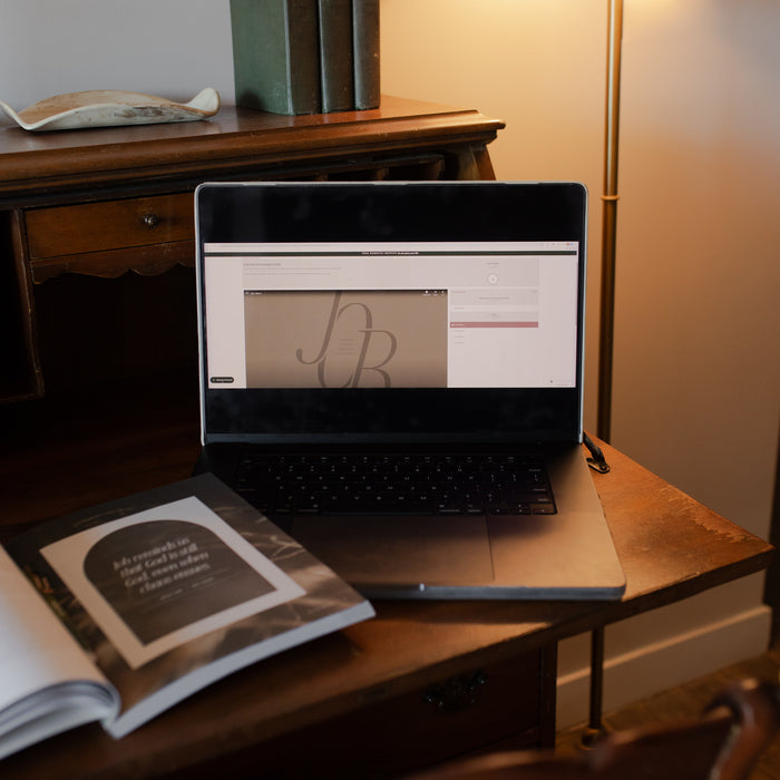 Job Group Leader Guide on a laptop near an open study on a wooden table