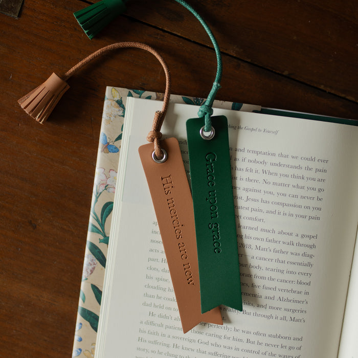 The Leatherette Bookmarks on an open book on a wooden table