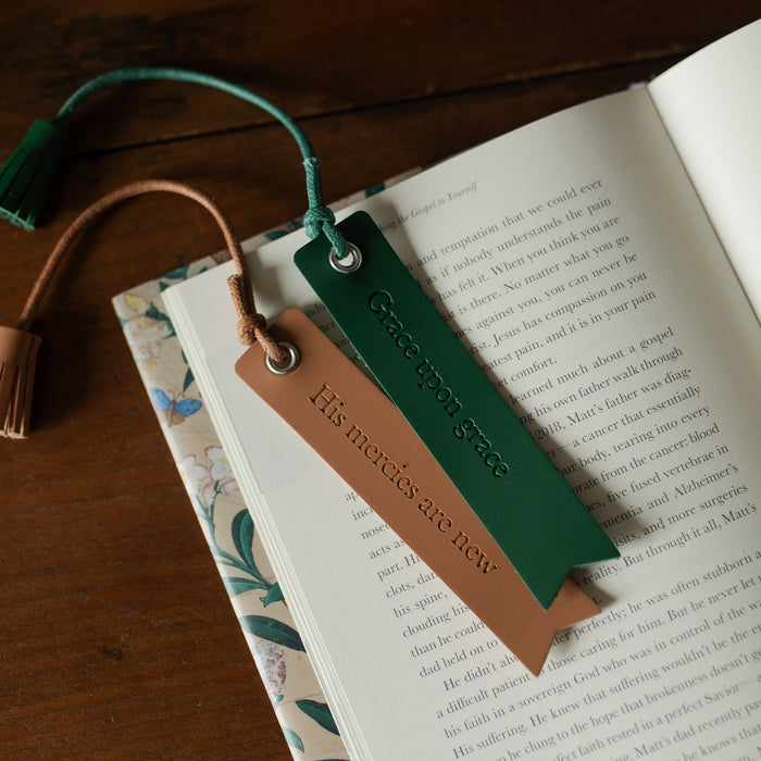 The Leatherette Bookmarks next to each other on an open book on a wooden table