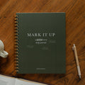 Mark It Up Journal cover next to a pen and a coffee cup
