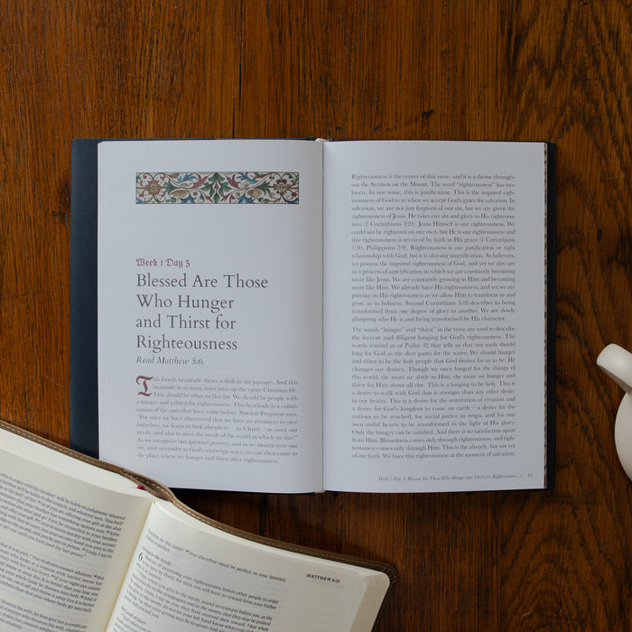 Open book on a wooden surface with text and decorative elements.