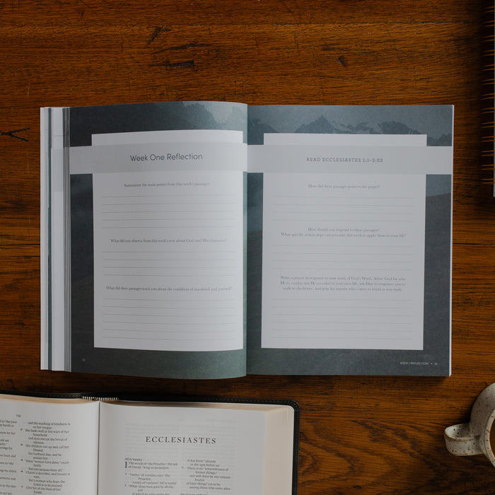 The Path to Purpose opened to the Week One Reflection page on a wooden table near an open bible