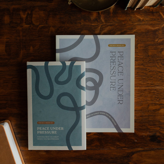Peace Under Pressure Men and Womens Study cover on a wooden table  next to a journal
