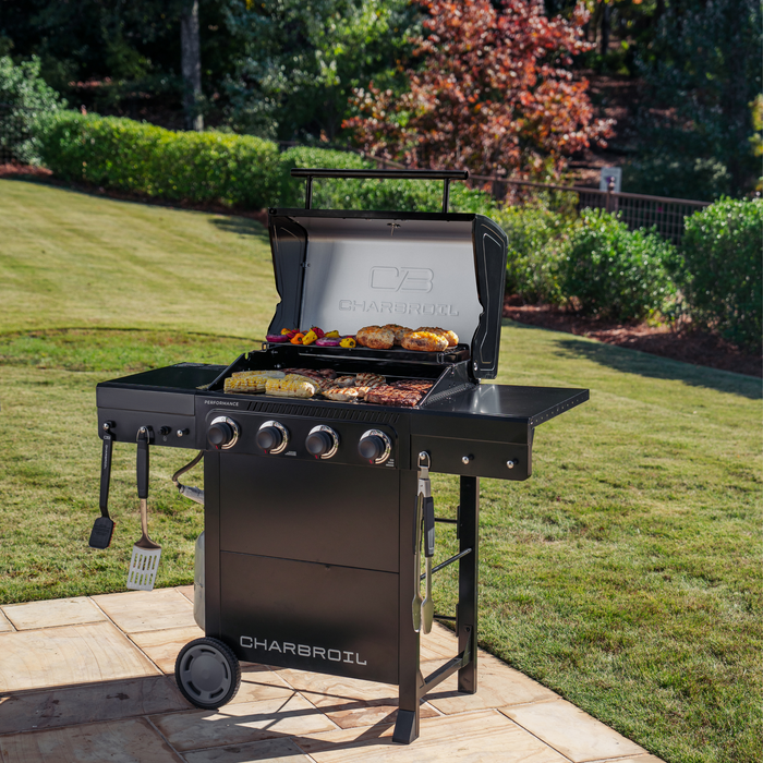 Black Char-Broil Performance Series gas grill with food cooking on the grates.
