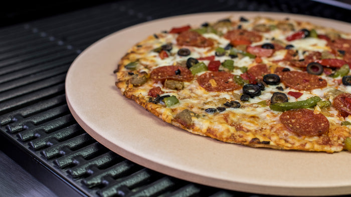 Pizza on beige plate with pepperoni, olives, peppers, and cheese.