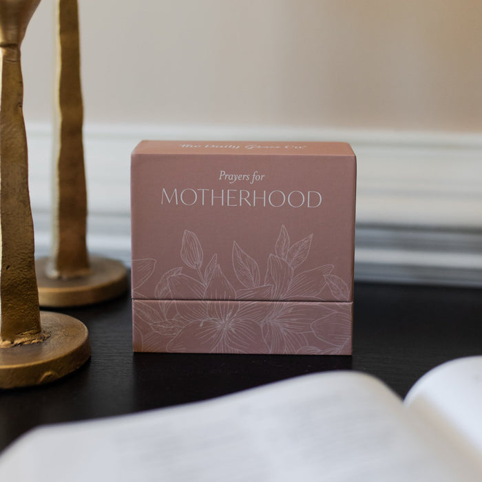 Prayers for Motherhood verse cards in a pink flowery case on a dark table