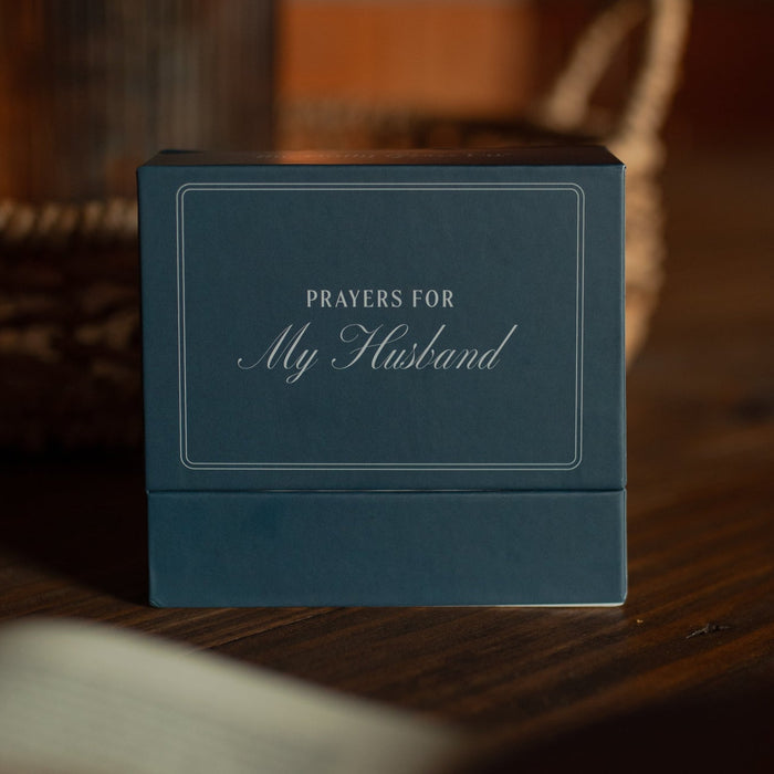 Blue box with 'Prayers for My Husband' text on a wooden surface near a potted plant
