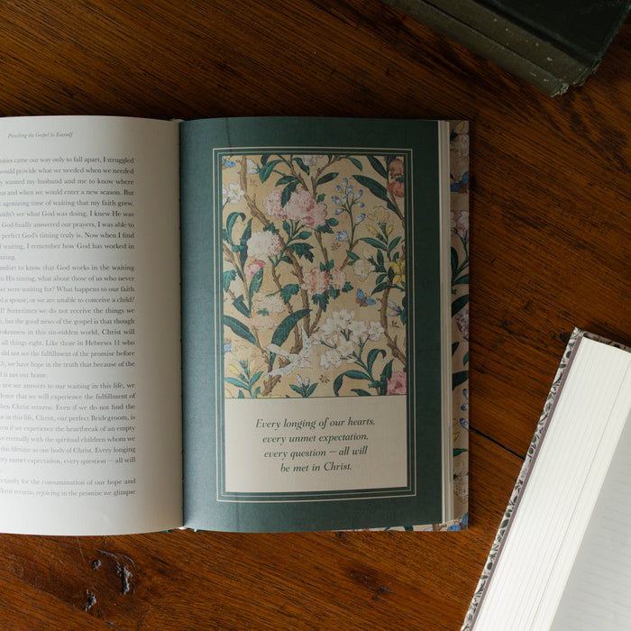 Preaching the Gospel to yourself opened to a page design about Every Longing of our hearts page on a wooden table