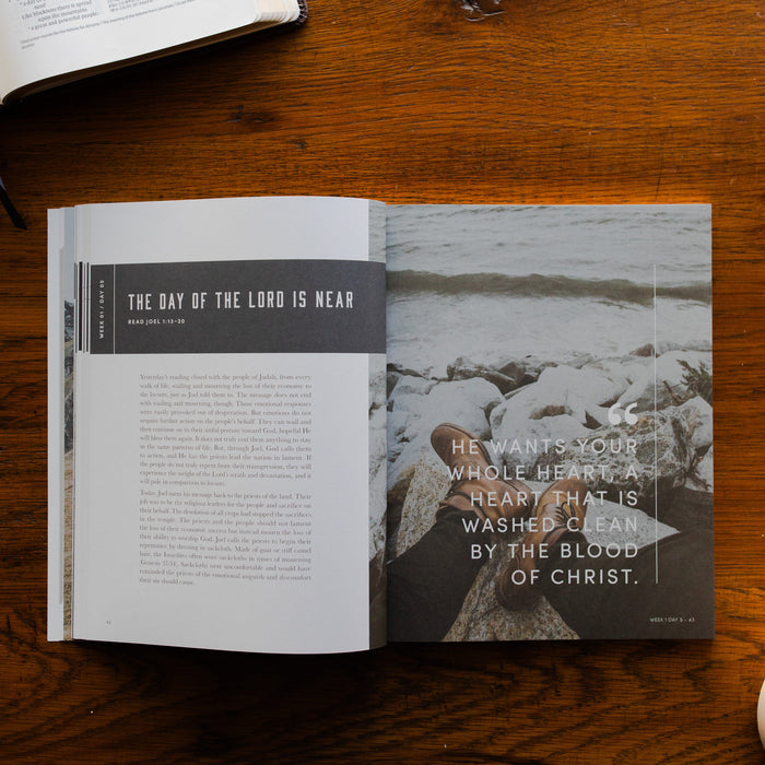 Restored Mens Study opened to the day of the lord is near page on a brown wooden table next to an open book