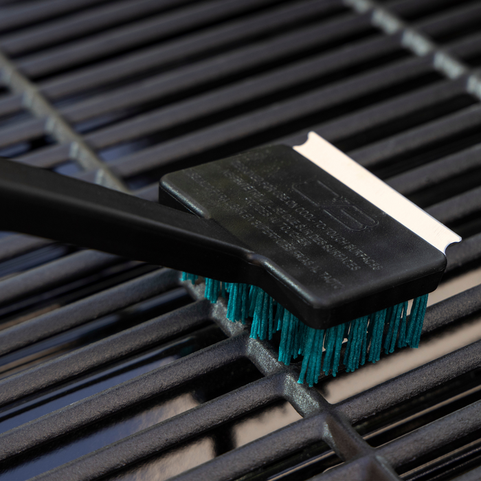 Black grill brush with teal bristles and handle, designed for cleaning grates.