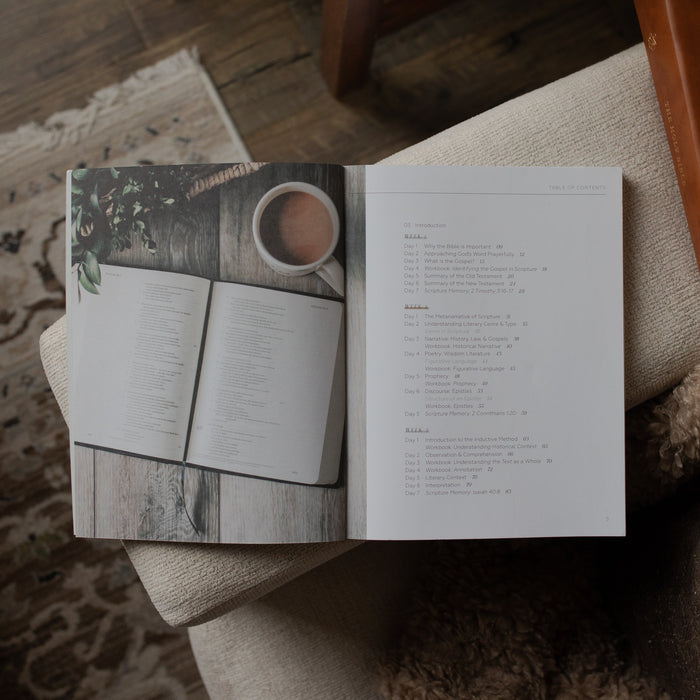 Open book with a coffee cup illustration on a wooden surface