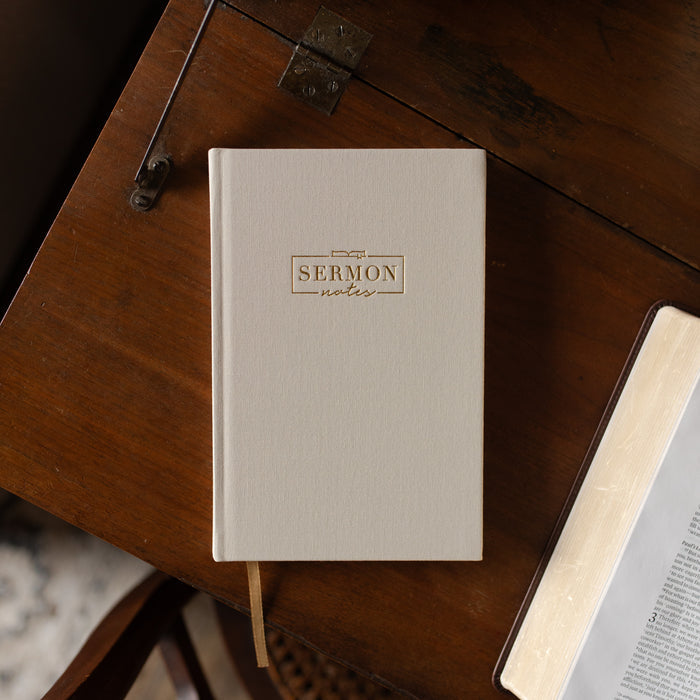 Beige notebook titled 'Sermon Notes' on a wooden surface