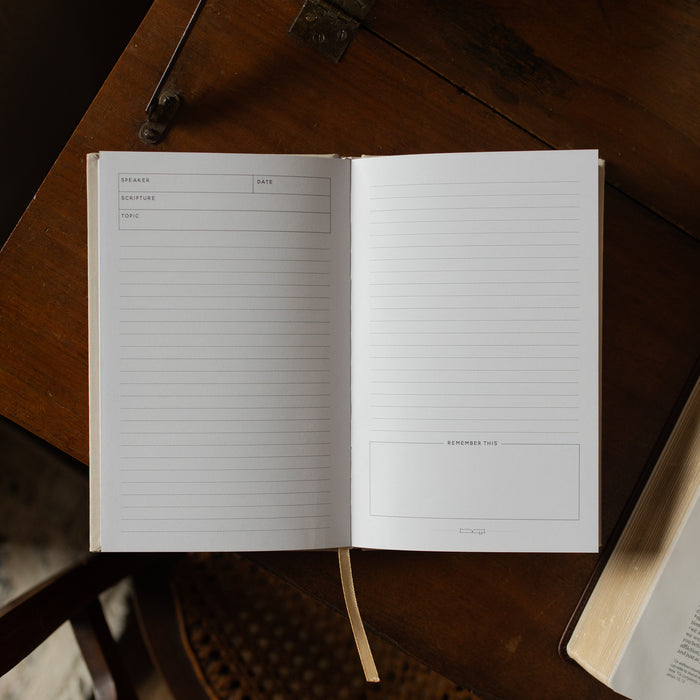 Open notebook with lined pages on a wooden surface