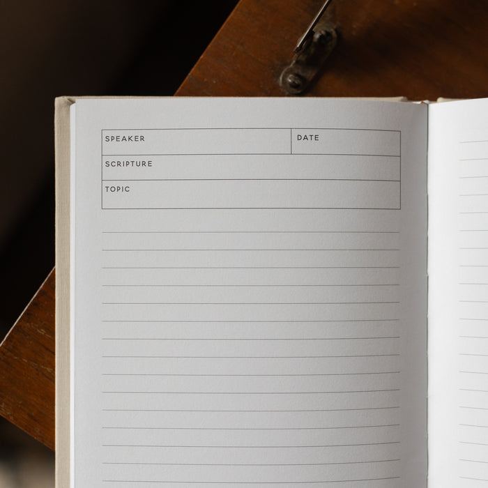 Notebook with pre-printed columns on a wooden surface