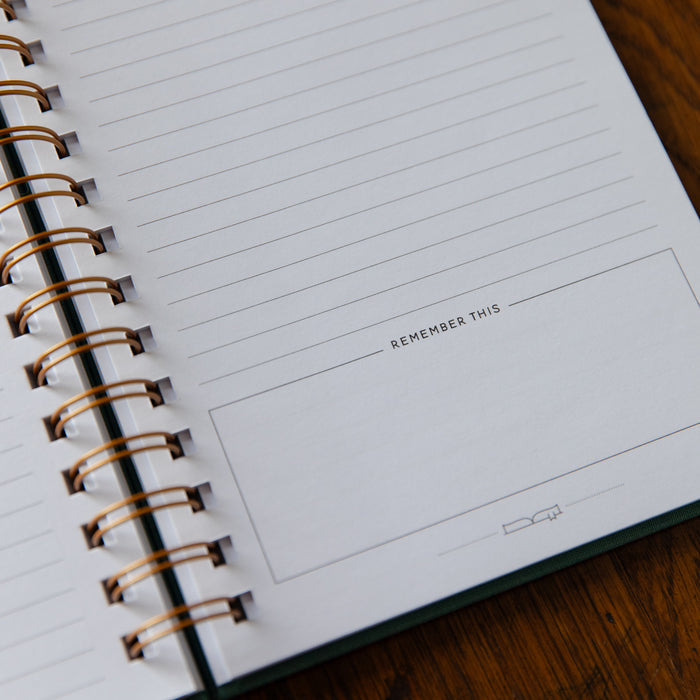 Notebook with lined pages and 'Remember This' text on a wooden surface