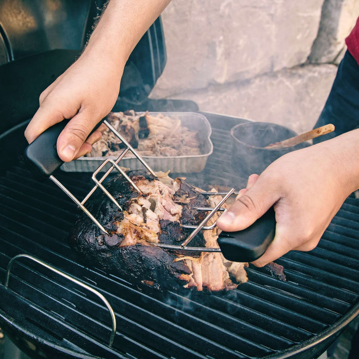 Metal grill basket holding meat on barbecue.