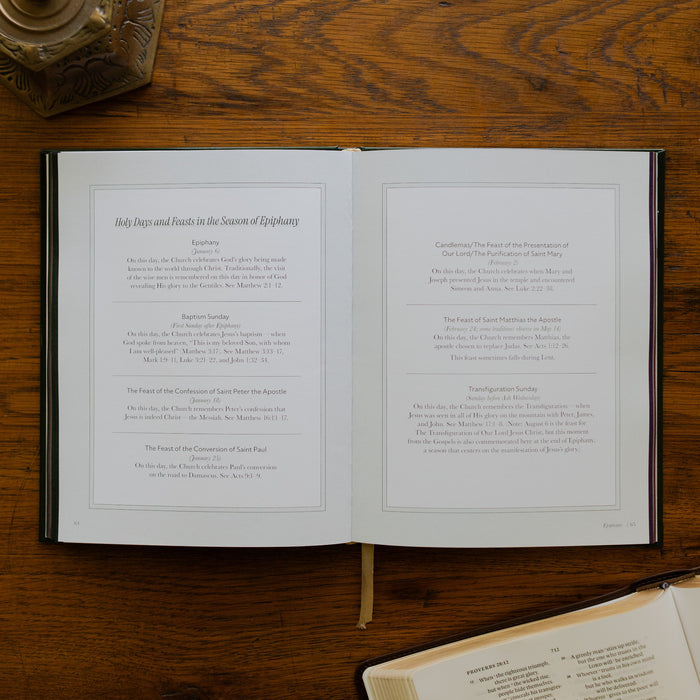 The Church Calendar opened to the Holy Days and Feasts in the Season of Epiphany page laying on wooden table next an open bible and a bronze candlestick