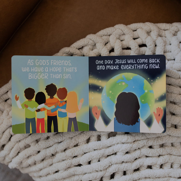 Jesus Makes Everything New Board Book opened to an God's friends page laying on a white knitted blanket