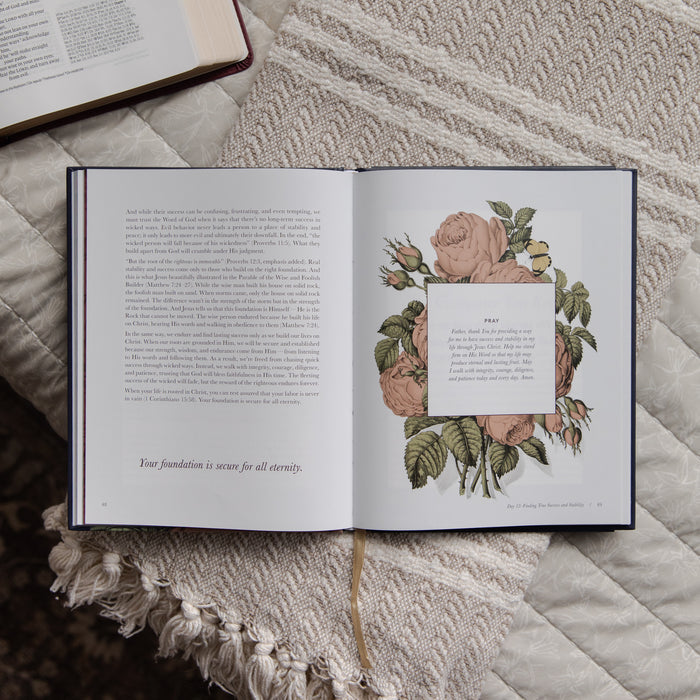 Open devotional with floral design on a textured surface