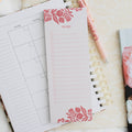 photo of notepad on top of planner next to pen