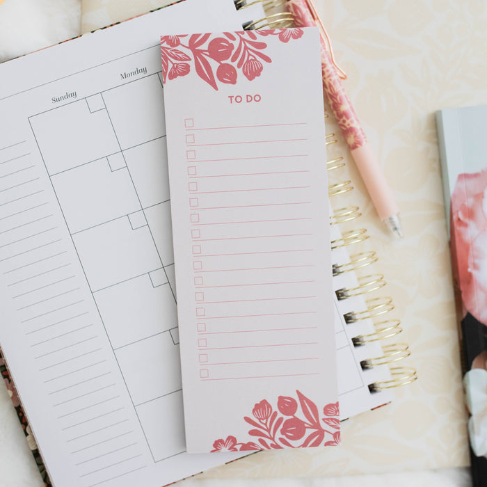 photo of notepad on top of planner next to pen