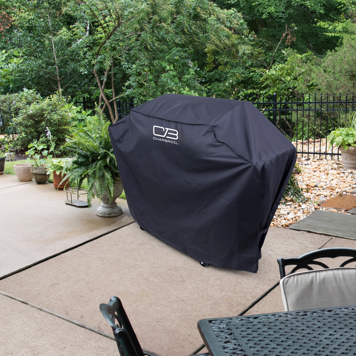Black Char-Broil grill cover on patio with potted plants and outdoor furniture.