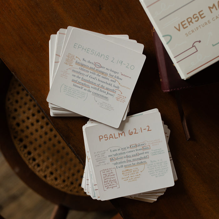The Verse Map cards stacked on a wooden table in one stack with the verses facing toward the camera