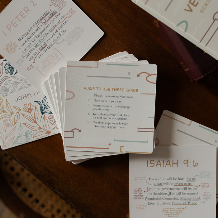 Multiple Verse Cards spread over a wooden table with instructions on the top of the stacks