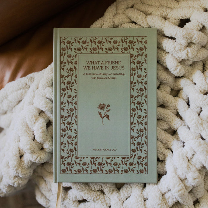 What a friend we have in Jesus cover on a white knitted blanket on a leather couch