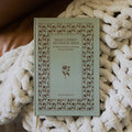 What a friend we have in Jesus cover on a white knitted blanket on a leather couch