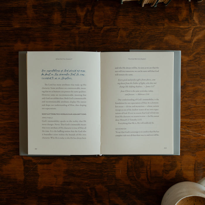 What did you expect book opened to page 62 on a wooden table near a coffee cup